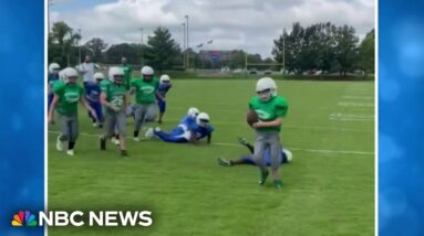 Elementary school football teams come together to set up special play for teammate